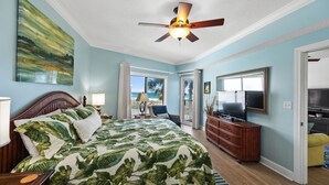 A bedroom with a bed, a ceiling fan, a TV, and a view of the beach. - Spacious 1BR/1.5BA Beach Condo/Low-Density Complex: Booking for Spring & Summer (Orange Beach)