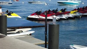 Een jachthaven met verschillende vaartuigen, waaronder jetski's en boten.