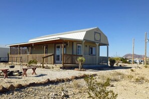 A small building with a porch, a small garden, and a desert landscape. - Lorna’s Ghost Town Cabin: Located in Ghost Town (Terlingua)