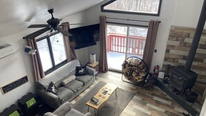 Un salon moderne comprenant un canapé, un fauteuil, une table basse et une cheminée.