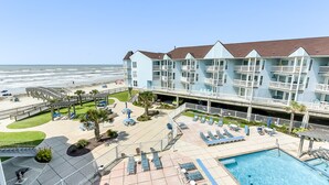 A beachfront hotel with a pool, lounge chairs, and a view of the ocean. - AMAZING- beach condo overlooking Pool & Gulf of Mexico 2309 (Galveston)