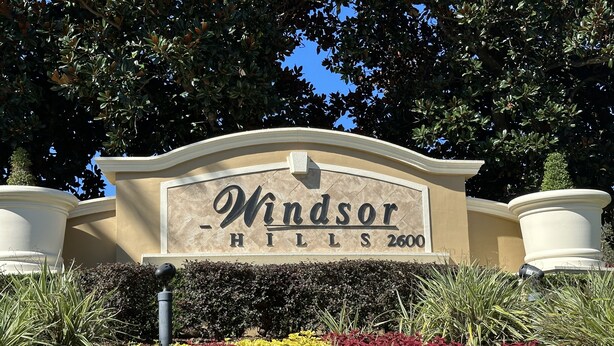 Señal de Windsor Hills con un jardín ajardinado en primer plano.