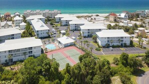 A resort with multiple buildings, a tennis court, and a view of the ocean. - Beachside Villas - lovely 2BR/2BA unit south of 30A, steps from the beach! (Seagrove Beach)