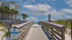 A wooden boardwalk leading to a beach with a sign promoting social distancing and a yellow flag. - Beachside Villas - lovely 2BR/2BA unit south of 30A, steps from the beach! (Seagrove Beach)