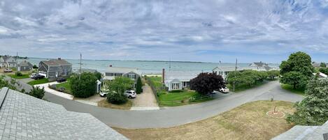 A residential area with houses, a driveway, and a view of the sea.