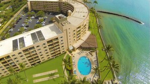 A resort with a pool, a beach, and a view of the ocean.