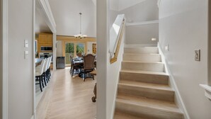A spacious interior with a wooden staircase, a dining area, and a kitchen. - Mountain retreat, epic views, hot tub, decks, game room. A/C, Non-smoking. (Durango)