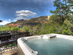A hot tub with a mountainous backdrop, surrounded by a deck with outdoor seating. - Mountain retreat, epic views, hot tub, decks, game room. A/C, Non-smoking. (Durango)
