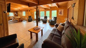 A spacious cabin interior with a dining area, seating, and a fireplace. - Riverfront, with Hot Tub & Deck Overlooking the River! Sandy beach steps away! (Leavenworth)