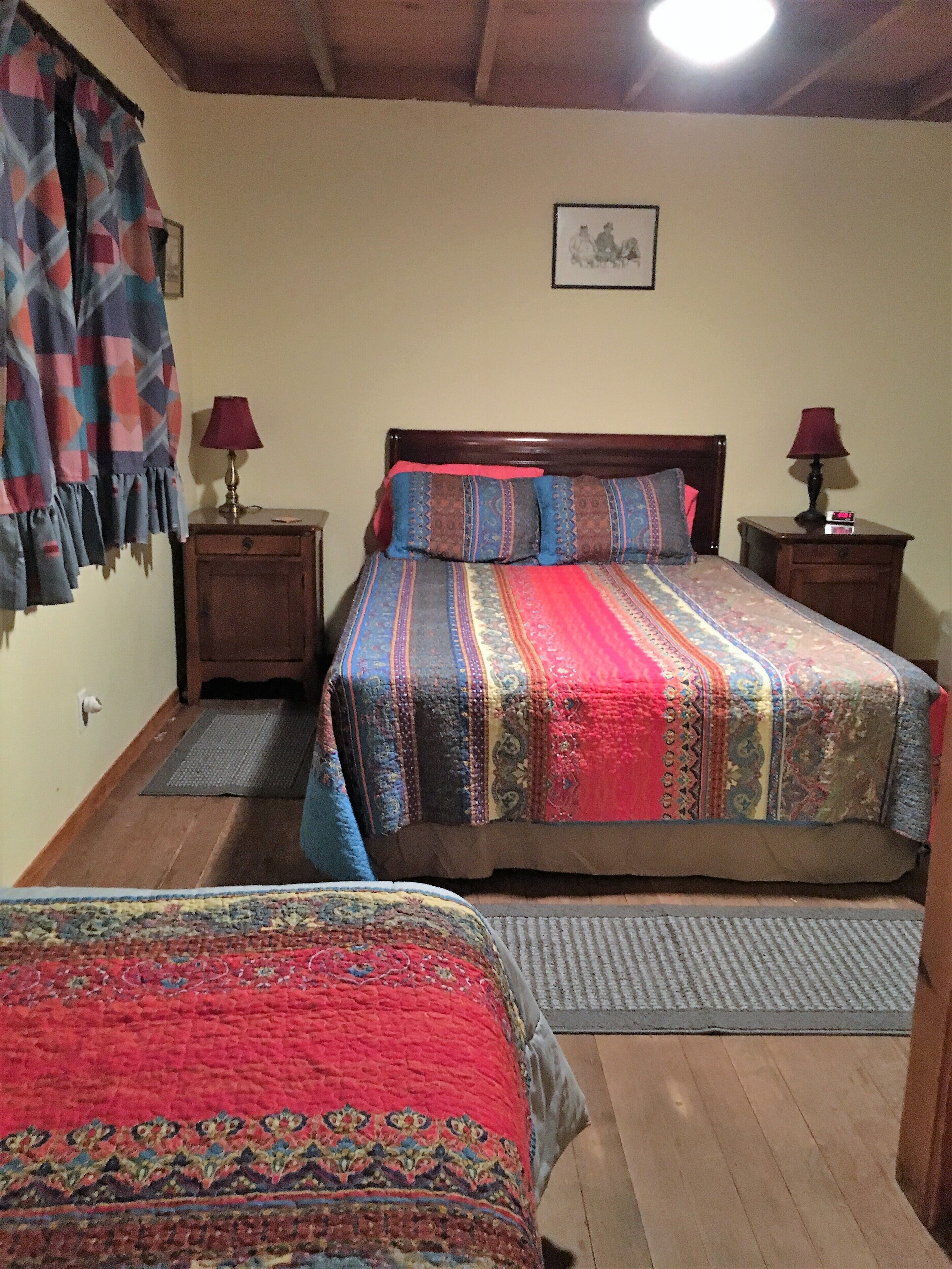 Un dormitorio con dos camas, cabeceros de madera y ropa de cama estampada.