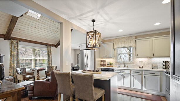 A modern kitchen with white cabinets, a stainless steel refrigerator, and a large island with bar stools. - Great Location/100 yd. to lift, Club Member, Walk To Resort & Fire pit!  (Beech Mountain)