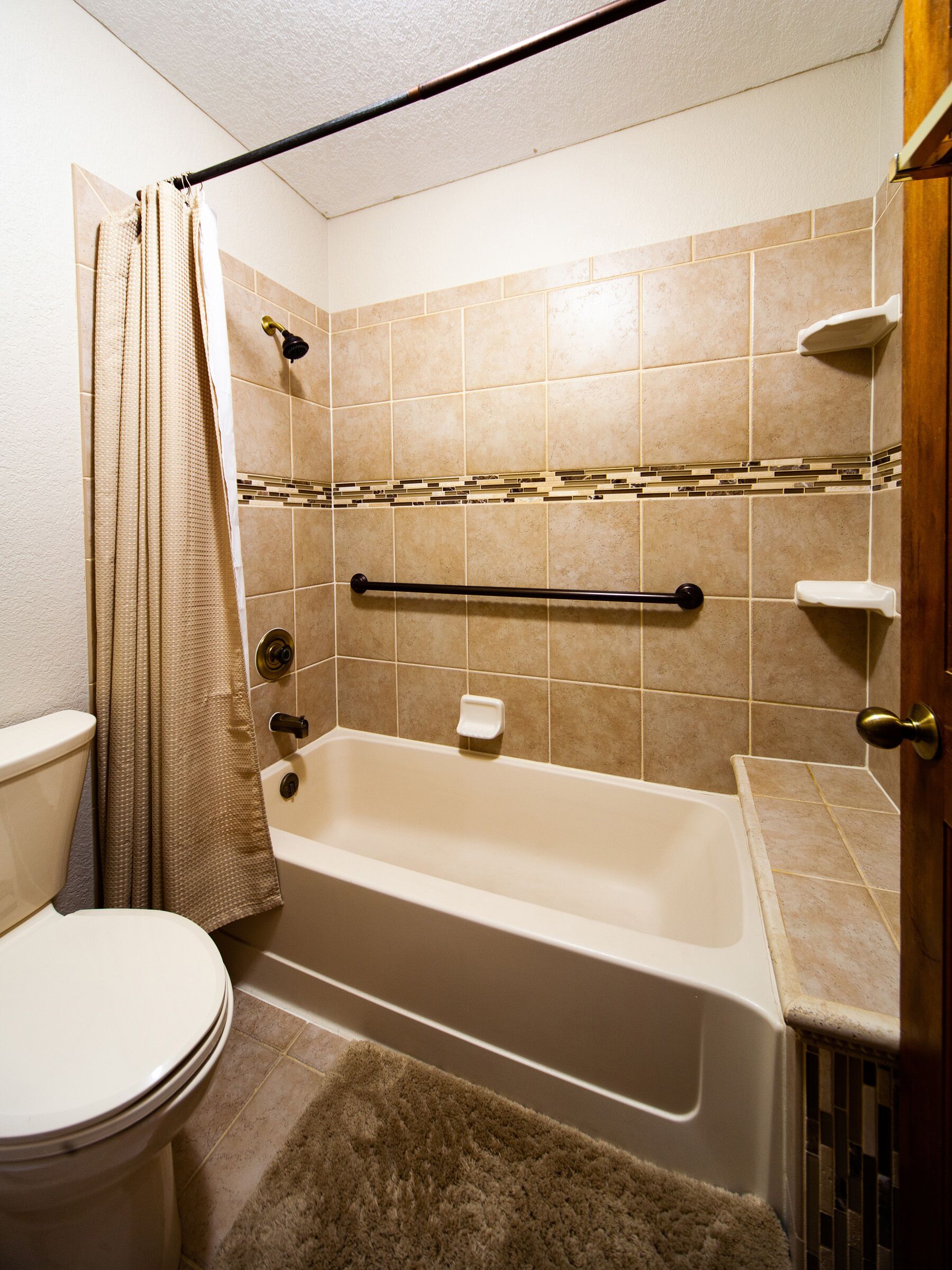 Ein Badezimmer mit Badewanne, Toilette und Duschvorhang.