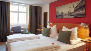 A hotel room with two beds, a large window, a painting on the wall, and a radiator. - Hotel Engel Lindauer Bier Und Weinstube (Lindau)
