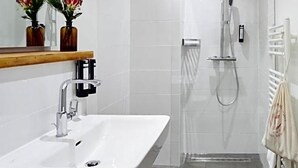 A modern bathroom with a white sink, mirror, and shower. - Hotel Engel Lindauer Bier Und Weinstube (Lindau)
