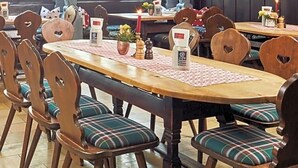 A restaurant with wooden tables and chairs, hanging lamps, and large windows. - Hotel Engel Lindauer Bier Und Weinstube (Lindau)