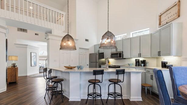 A spacious kitchen with a central island, pendant lighting, and a view of the upper level. - Blue Haven, Tivoli, Sandestin, Golf Cart (Miramar Beach)