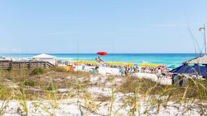 A beach with a wooden boardwalk, beach umbrellas, and a clear blue sky. - Blue Haven, Tivoli, Sandestin, Golf Cart (Miramar Beach)