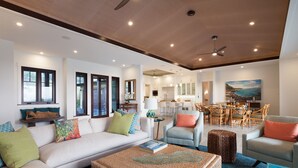 A spacious living room with a sofa, chairs, a coffee table, and a dining area with a table and chairs. - Ocean Views/Private Swimming Pool. Mauna Kea High Bluffs Home (Mauna Kea Beach Resort)