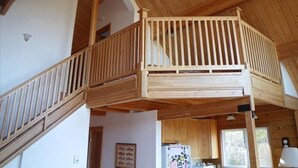 A wooden interior with a lofted sleeping area, a kitchen with wooden cabinets, and a staircase. - ⚓️ Nautical Sea Cabin with Water View ⚓️ (Lopez Island)