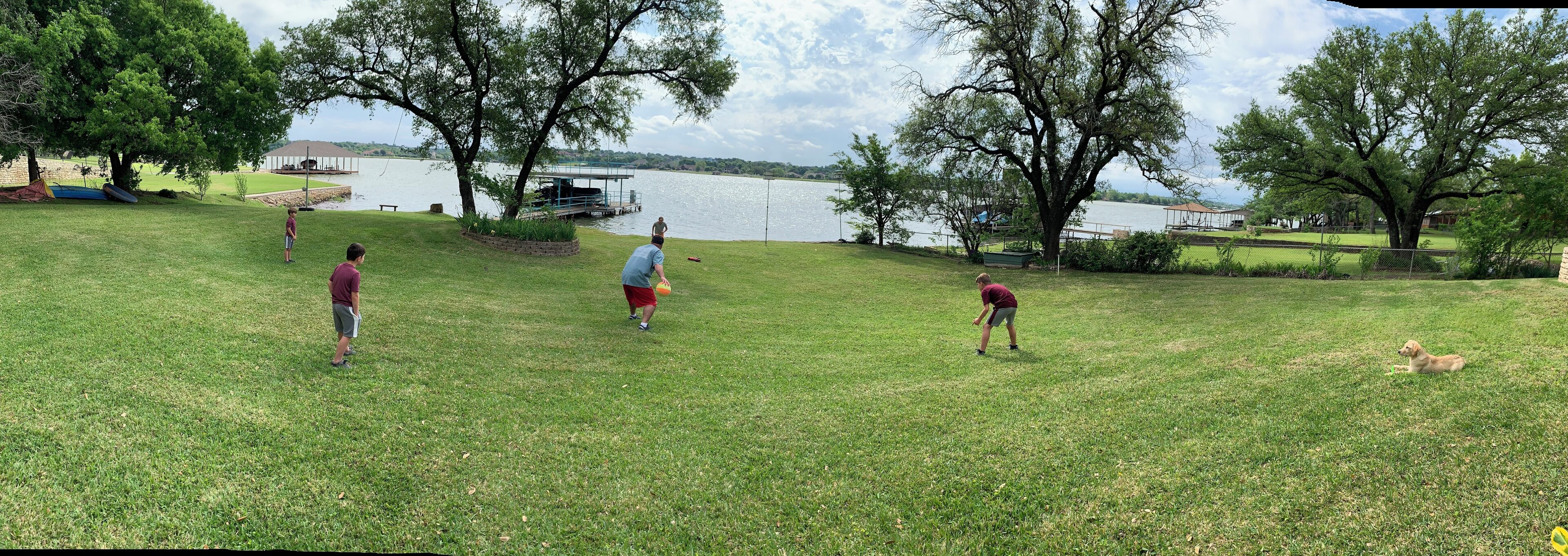 Un área con césped, un lago, árboles y un pabellón.