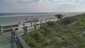 A beach with a wooden boardwalk, beach umbrellas, and a small pavilion. - Affordable, Comfortable 2 Bed, 2 Bath Villa - walk to beach! (Kiawah Island)