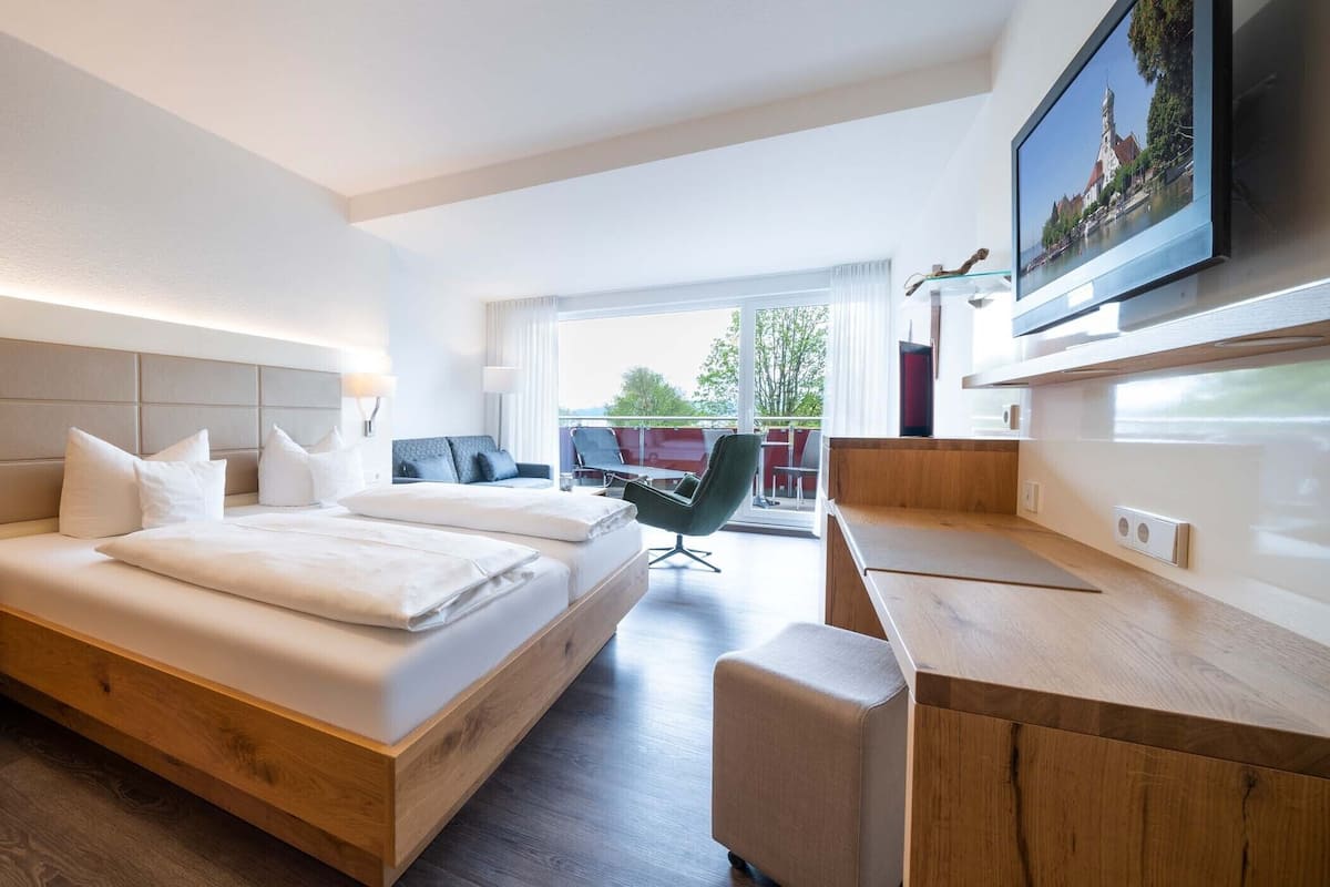 Een moderne hotelkamer met een groot bed, een bureau en een televisie.