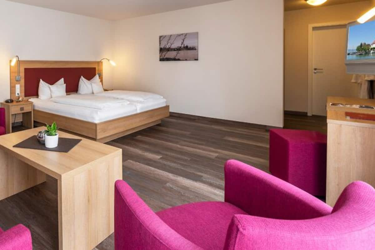 Een moderne hotelkamer met een bed, een bureau, een stoel en een bank.