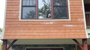 Un bâtiment à deux étages, avec un revêtement en bois et des éléments décoratifs en pierre.