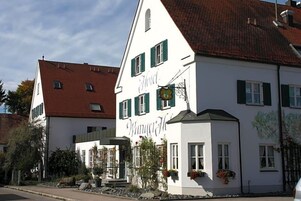 Un edificio blanco con contraventanas verdes y un letrero que dice 'Hotel Winterhof'.