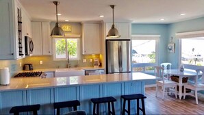 A modern kitchen with a large island, stainless steel appliances, and pendant lighting. - FULL OCEAN VIEW!!! 3 minute walk to beach, WiFi, Dogs welcomed upon approval (Cayucos)
