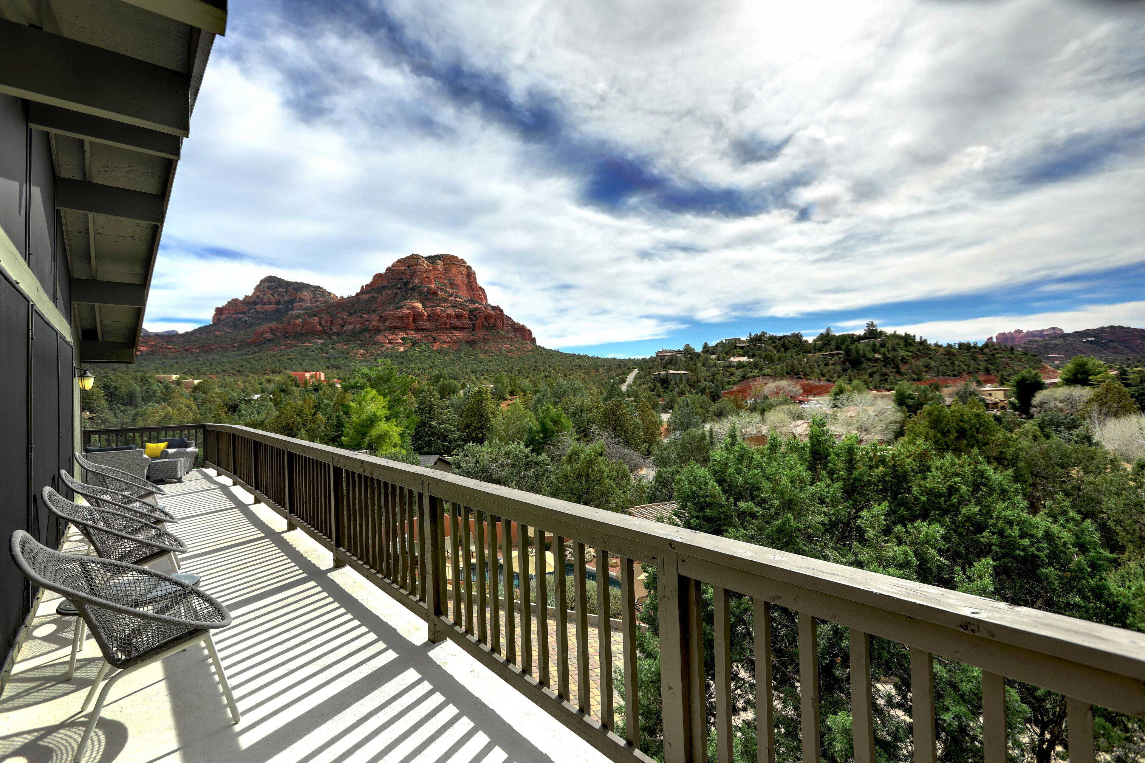 Un balcon offrant une vue sur des formations rocheuses rouges et des arbres verdoyants.