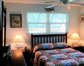 A bedroom with a bed, two bedside lamps, a ceiling fan, a window with blinds, and a framed picture on the wall. - Paradise at Its' Best. Your Home Away From Home....Pets welcome & Tesla Charger (Tequesta)