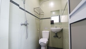 A small bathroom with a toilet, a sink, and a shower. - RedDoorz @ Baloi Batam (Batam)