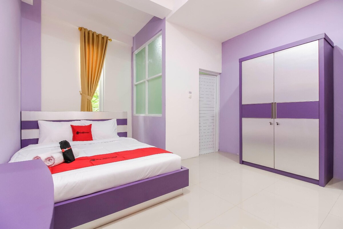 Une chambre à coucher avec un lit, une armoire et une fenêtre avec des rideaux.