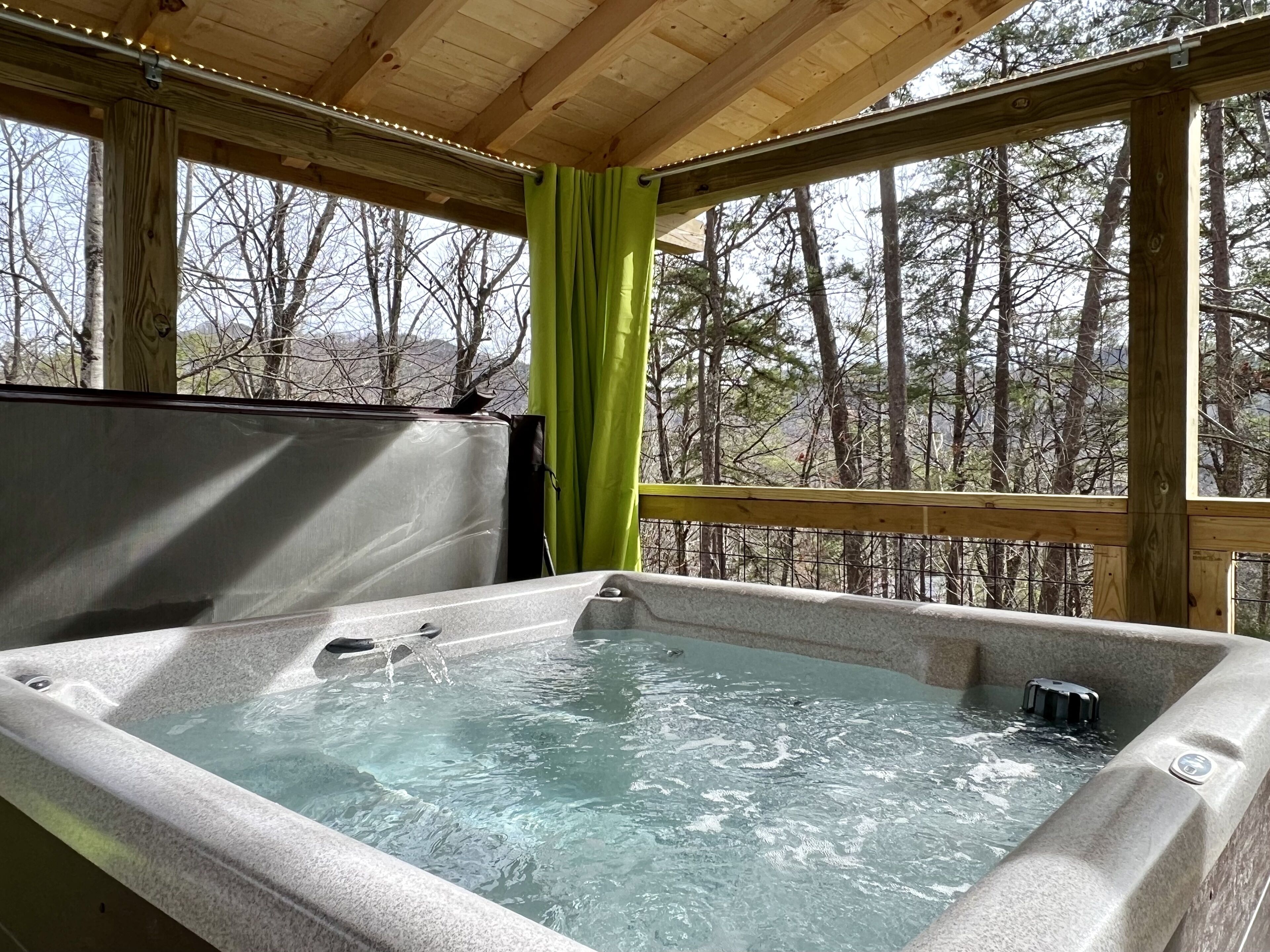 Un jacuzzi en una cabaña de madera con vistas a los árboles.