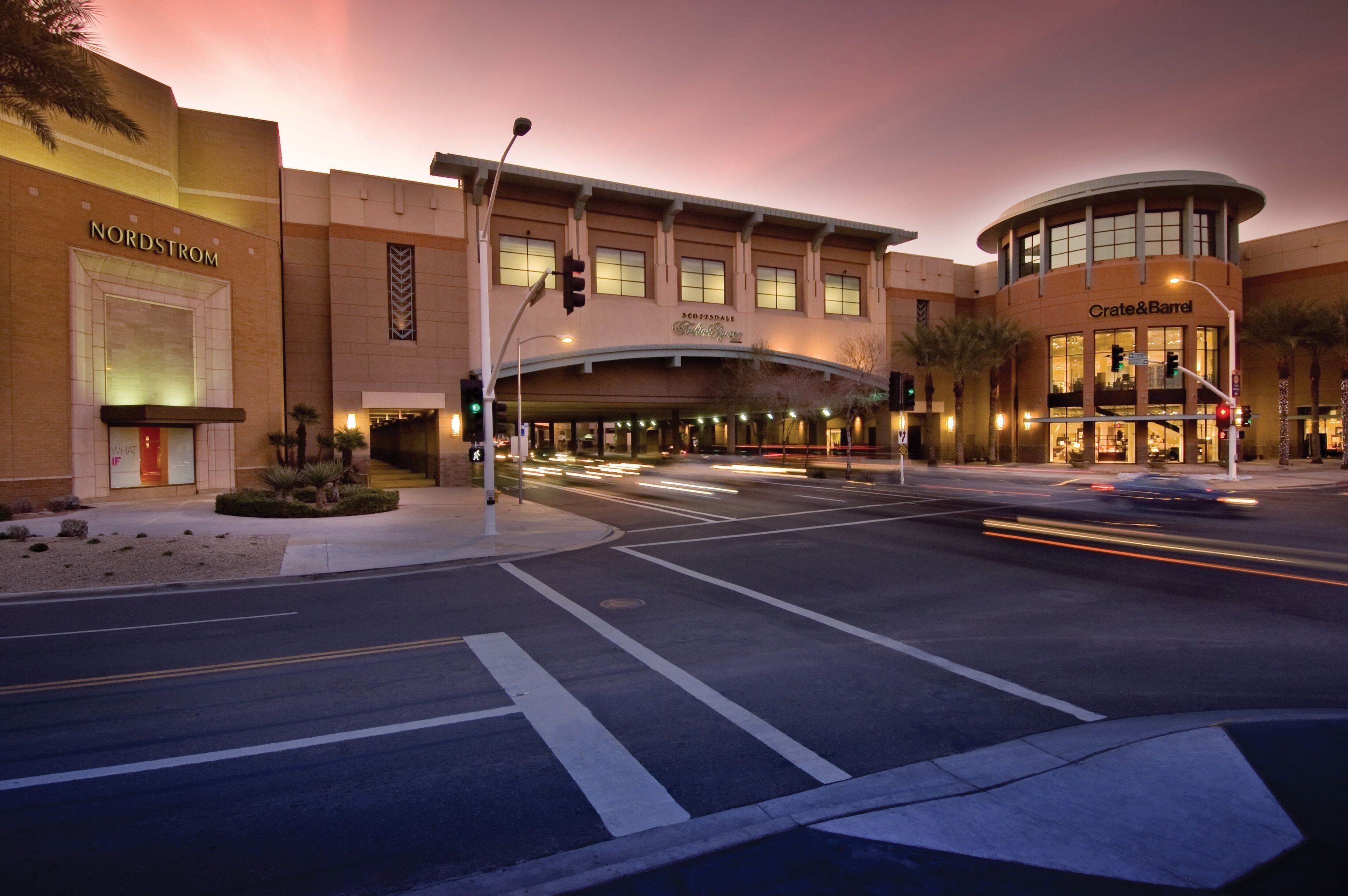 Uma loja da Nordstrom com uma entrada curva e uma loja da Crate & Barrel na rua de frente.
