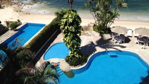 A resort pool with a view of the beach and ocean.