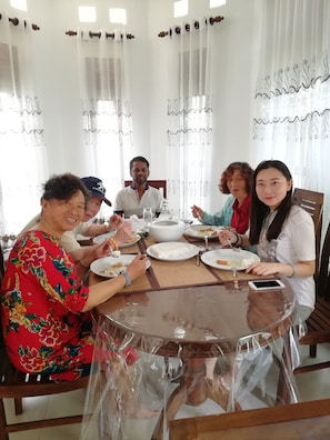 Enjoy meals in this dining area with a round table, set with plates, utensils, and a convenient charging station.