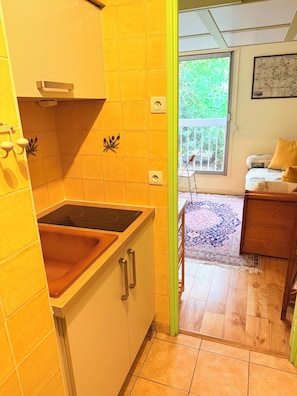 Une cuisine équipée d’une cuisinière intégrée, d’un évier et d’un meuble avec une poignée.