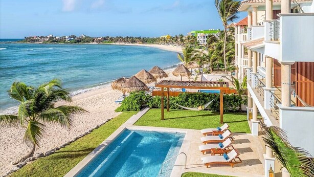A resort with a pool, beach, and ocean view. - Luxurious and elegant beachfront villa with a heated pool! (Akumal)