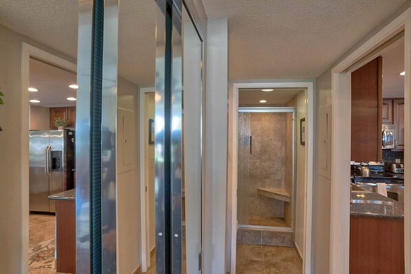 A modern kitchen with stainless steel appliances, a marble countertop, and a built-in oven.