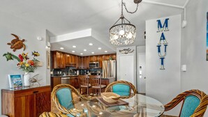 A modern kitchen with wooden cabinets, a stainless steel refrigerator, and a microwave. - Maui Banyan P304 - Remodeled, Partial Ocean View, AC, Across from Kamaole Beach! (Kihei)
