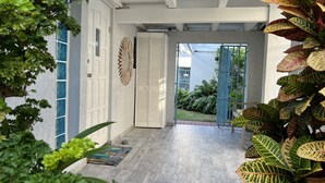 Un interior moderno con piso de madera, paredes blancas y una puerta azul.