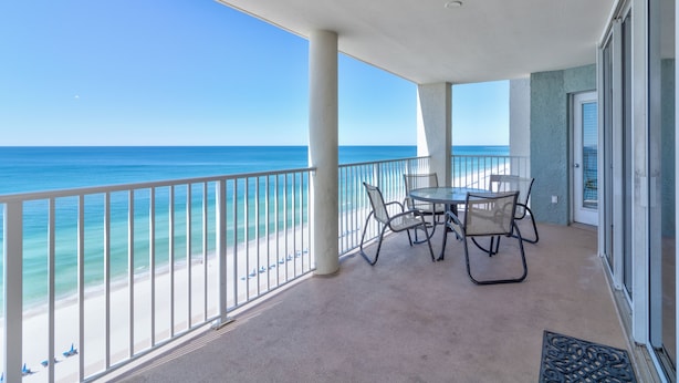A balcony with a view of the beach and ocean.