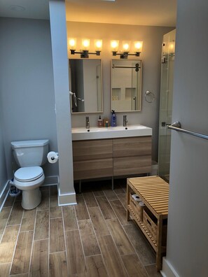 Une salle de bain moderne avec des toilettes, un lavabo et un miroir.