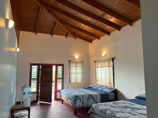 A room with two beds, a water dispenser, and a door leading outside.