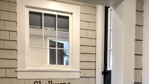 A room with a window, a wooden bench, and a welcome mat. - In town, newly remodeled studio with private balcony  (Shelburne Falls)