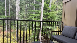 A balcony with a view of a forest, a wooden bench, a table, and a sofa. - Ideal location in Collins Lake, close to pool with views of Forest & the Slopes (Government Camp)