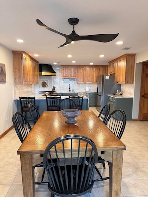 Enjoy meals at the central island in this kitchen, which features a dining table and comfortable seating for all.