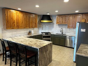 Enjoy cooking in this well-equipped kitchen with a large island, double oven, and stainless steel appliances.